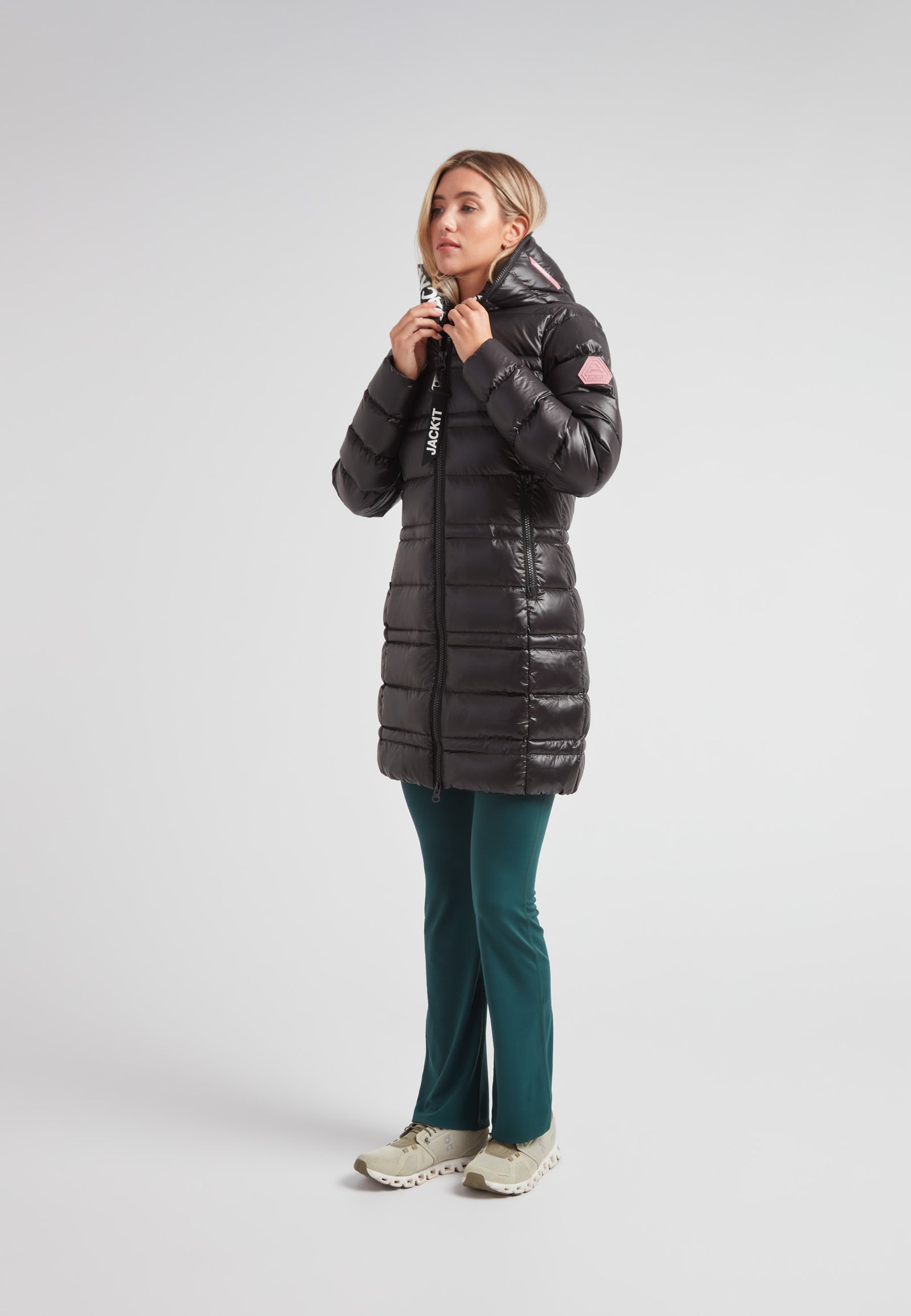 Woman wearing the R4D Tramline Down Coat Lux Black, stylish and warm, ideal for cold weather.