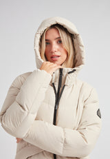Black Star Puffer Down Coat Stone model wearing a beige hooded winter coat indoors.