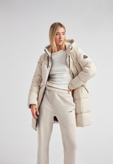 Black Star Puffer Down Coat Stone worn by a model in a light outfit showcasing a fashionable winter look.