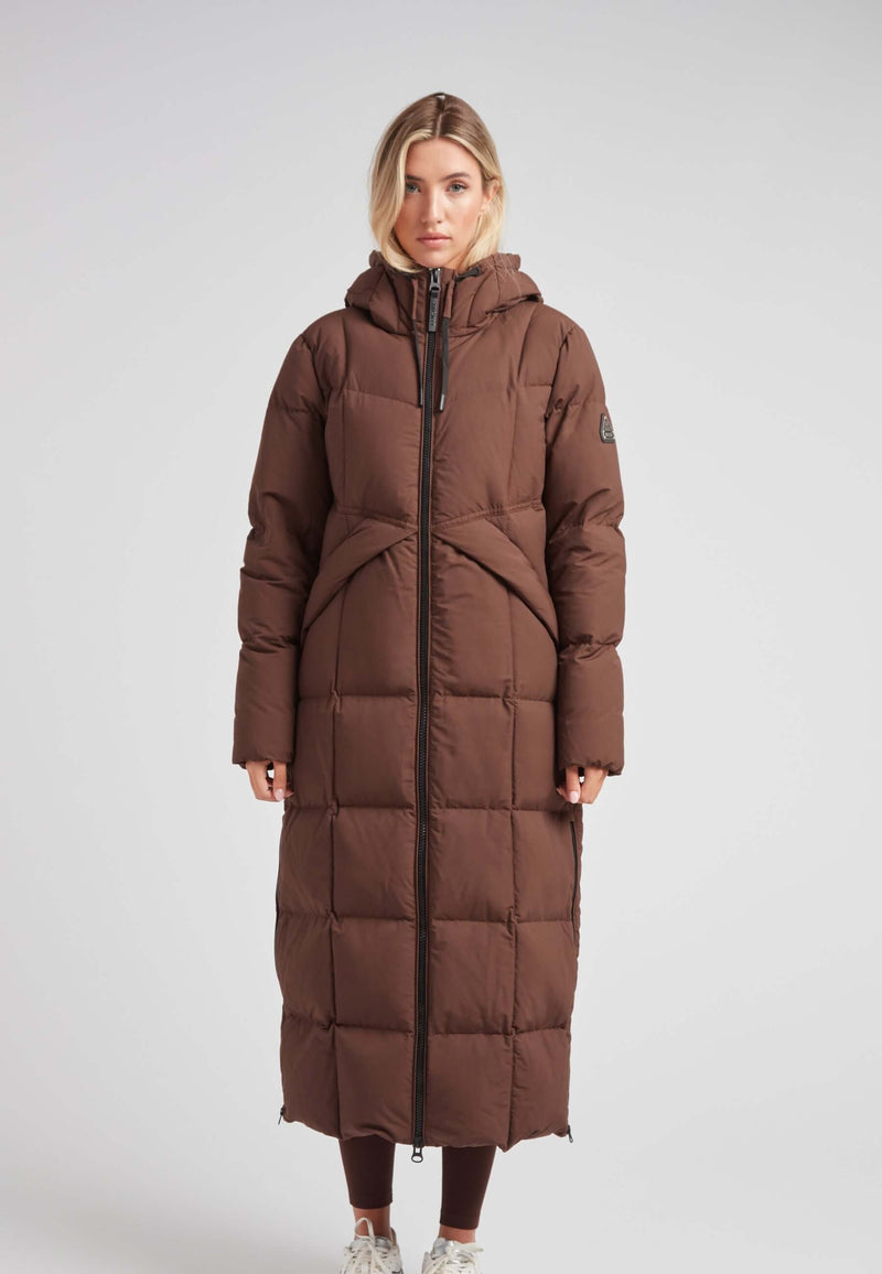 Black Star Extra Long Down Coat Matt Mid Brown worn by a model, showcasing its ankle-grazing design and hood.