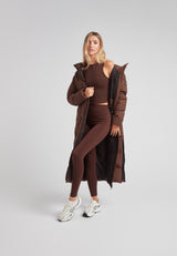Model wearing Black Star Extra Long Down Coat Matt Mid Brown, showcasing its extended design and modern style.