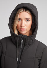 Woman wearing the Black Star Extra Long Down Coat Matt Black with adjustable hood.