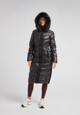 Model wearing the Diamond Belted Extra Long Down Coat Lux Black with a fur hood and stylish belt.