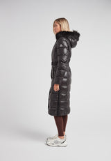 Model wearing the Diamond Belted Extra Long Down Coat Lux Black, showcasing its sleek design and faux fur hood.