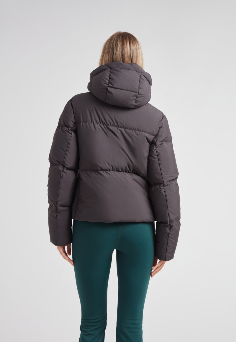 Back view of a woman wearing the Star Shower Down Puffer Jacket Black, featuring a hood and structured design.