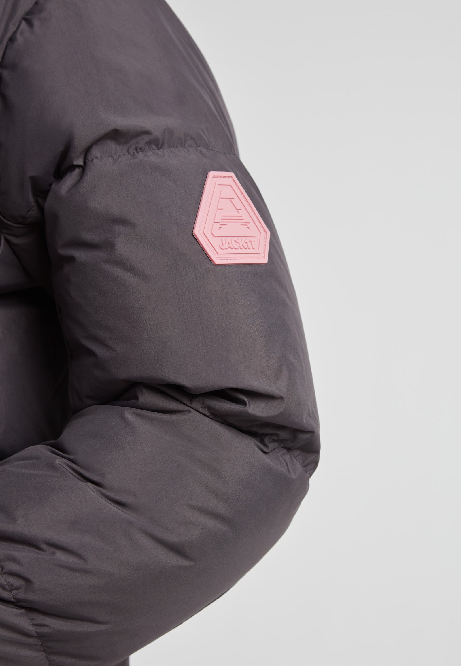 Close-up of the sleeve detail of the Star Shower Down Puffer Jacket Black with logo patch.