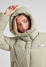 Woman wearing the Star Shower Down Puffer Jacket Sage with oversized hood, showcasing contemporary design and comfort.