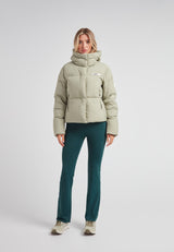 Star Shower Down Puffer Jacket Sage in light green worn by a woman with a stylish outfit.