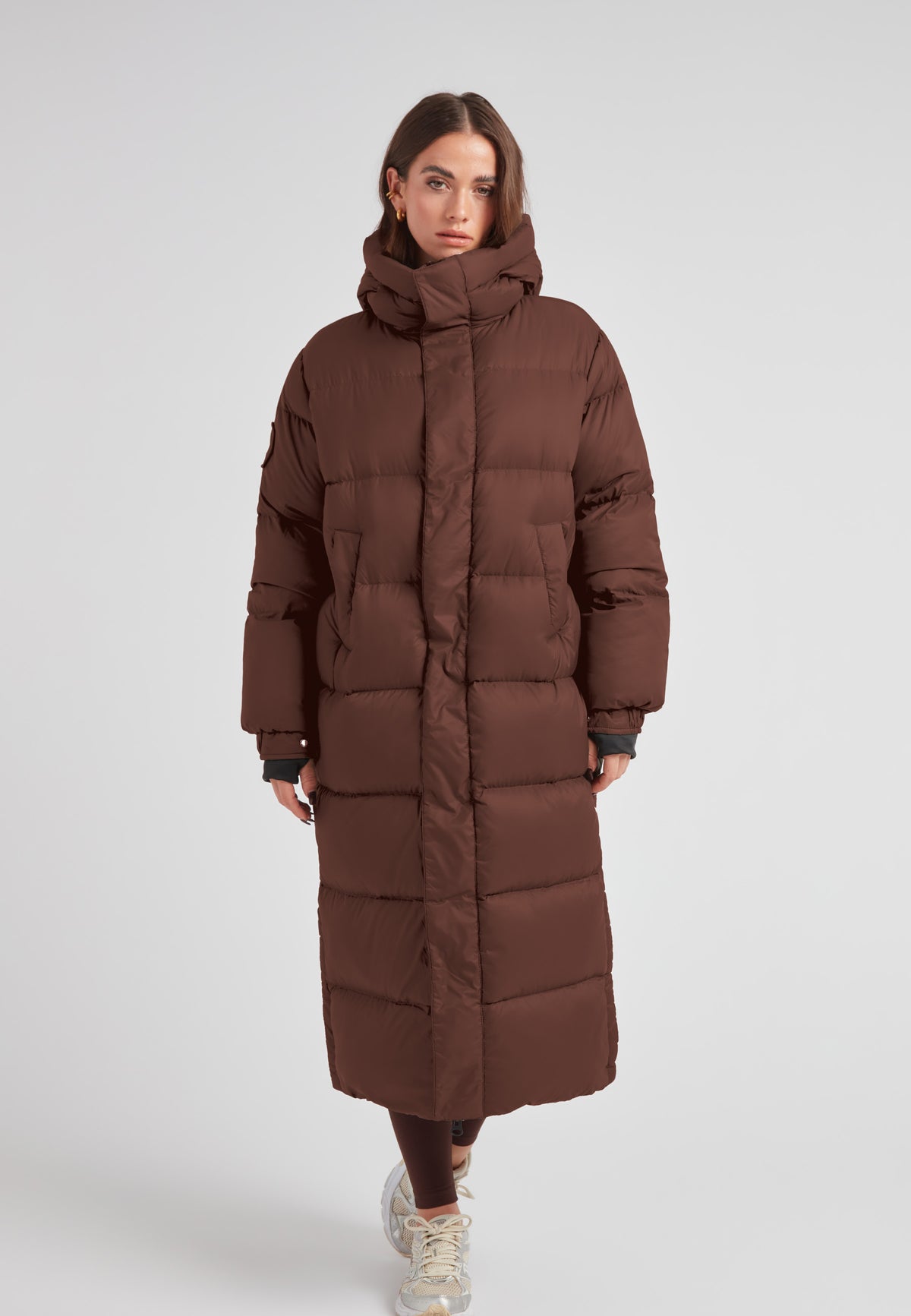 Cocoon Ultra Long Down Coat Mid Brown displayed on a model, featuring an oversized silhouette and a cozy hood.