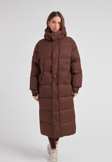 Cocoon Ultra Long Down Coat Mid Brown displayed on a model, featuring an oversized silhouette and a cozy hood.