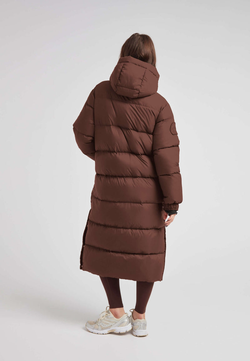 Back view of Cocoon Ultra Long Down Coat Mid Brown showcasing its oversized silhouette and warm design.