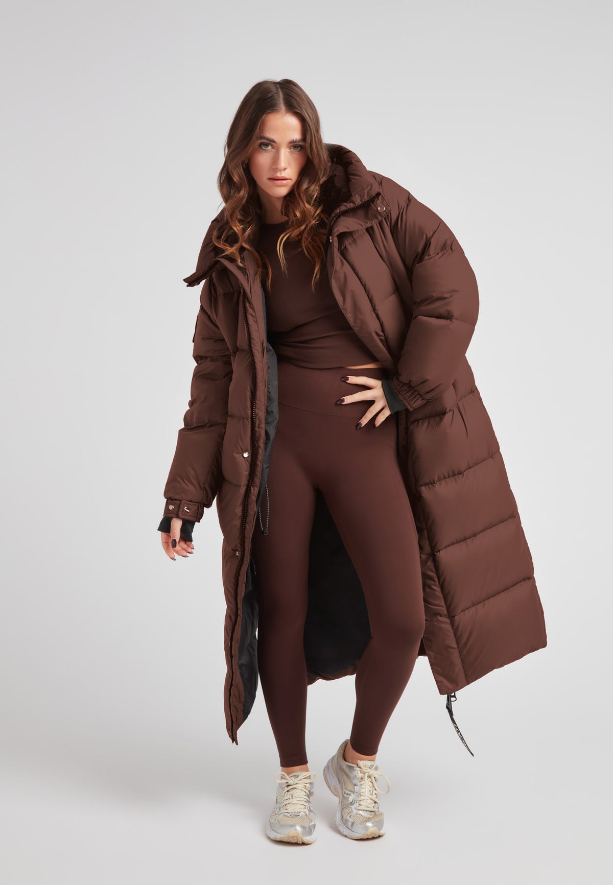 Cocoon Ultra Long Down Coat Mid Brown displayed by a model wearing matching brown attire.