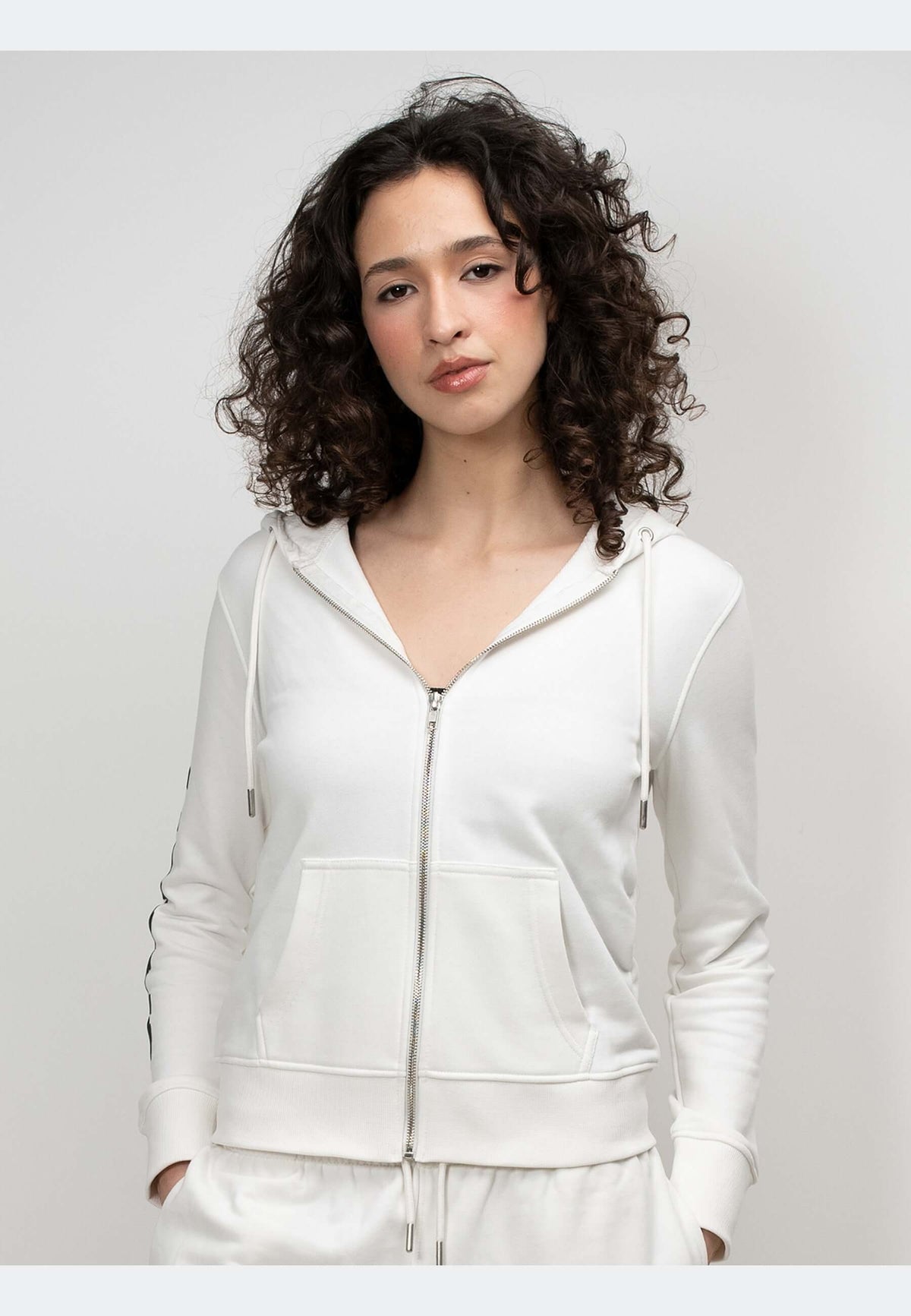 A model wearing an off white hoodie with a zip-through design, showcasing relaxed comfort and premium detailing.
