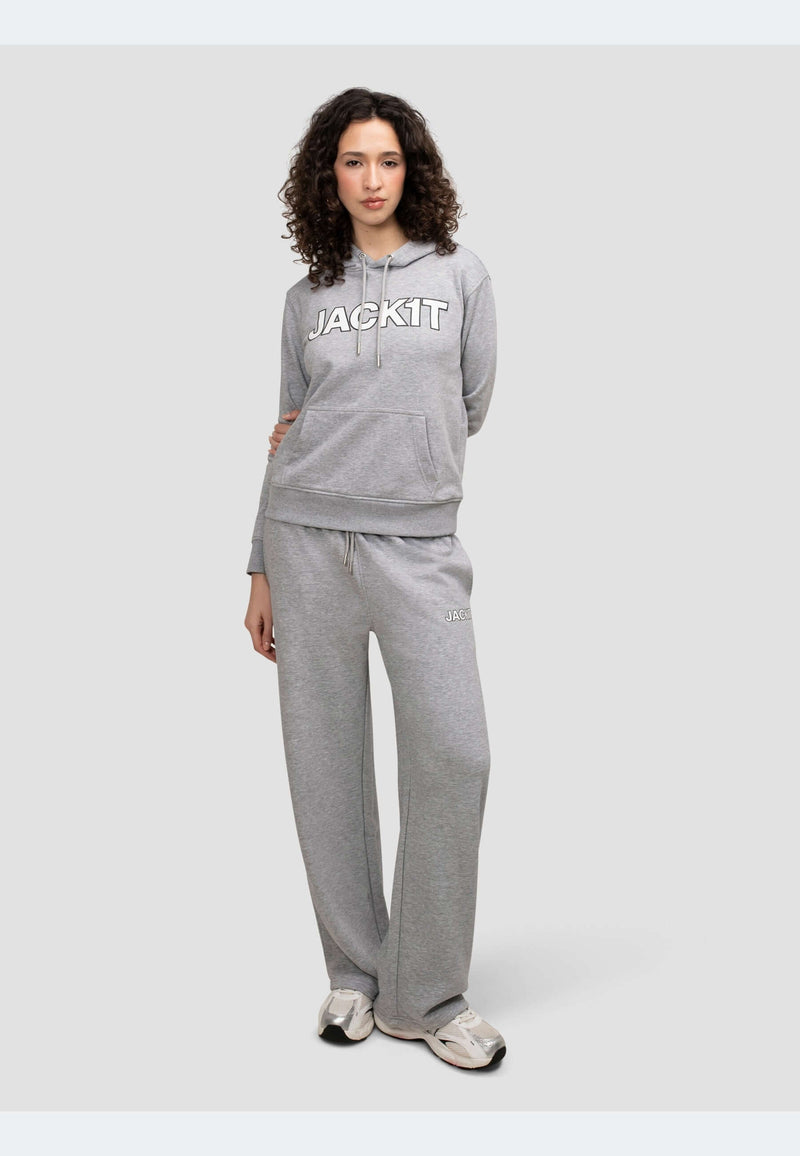 Stylish model wearing a grey hoodie with logo and matching pants in mid grey heather, showcasing relaxed comfort.