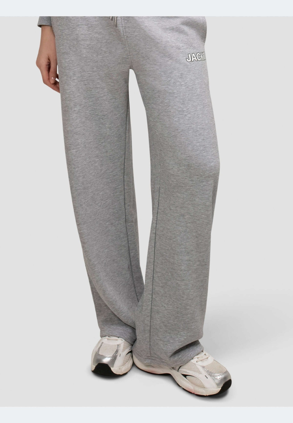 Wide-leg grey joggers with elastic waistband and side pockets, paired with stylish sneakers.