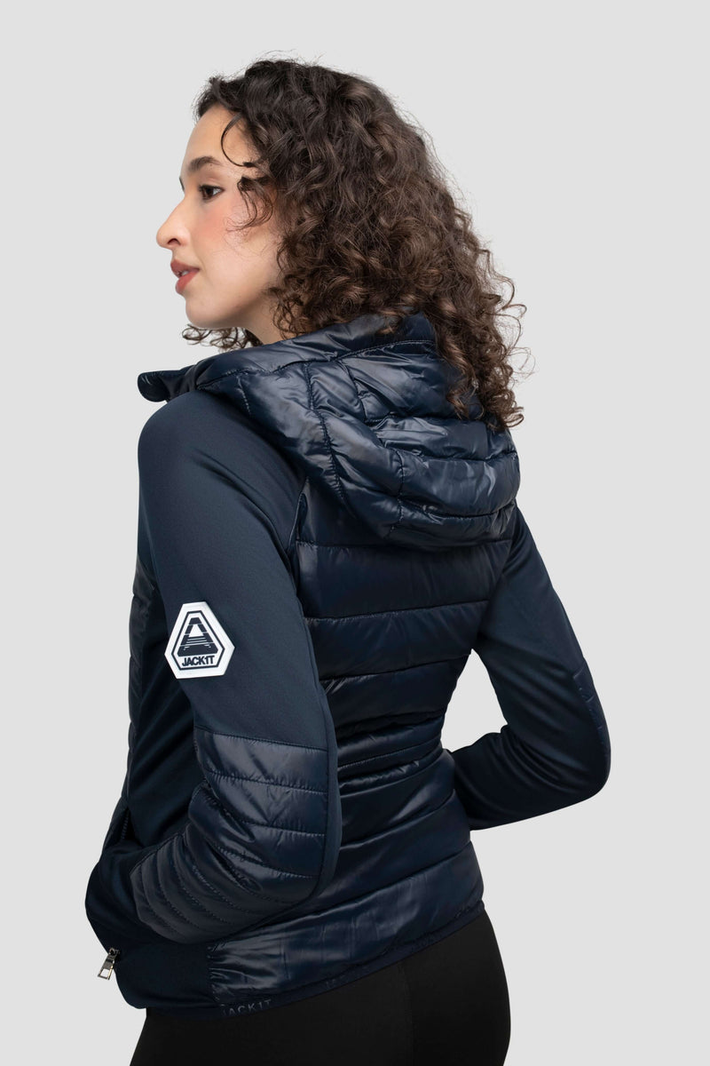 Model wearing a women's navy hooded jacket from the back, showcasing its lightweight design and stylish hood.