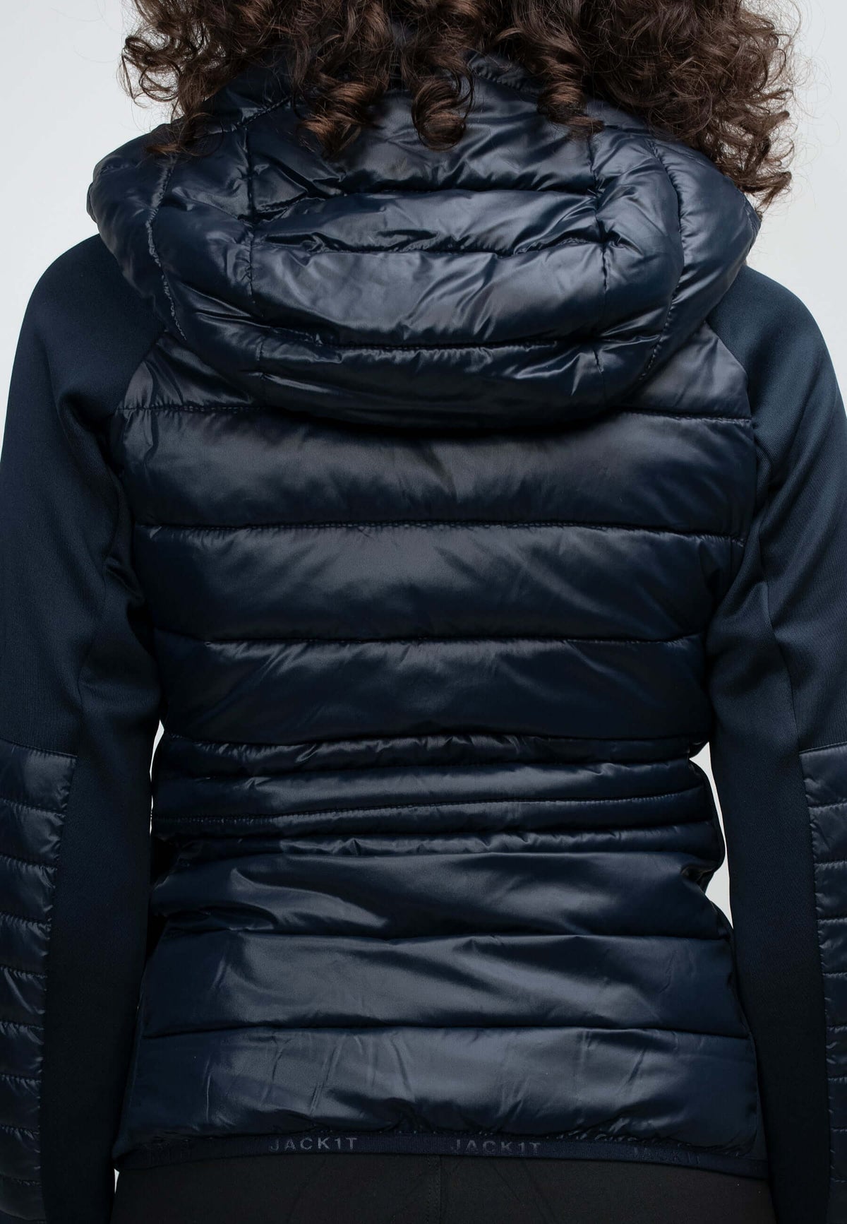 Back view of women's navy hooded jacket showcasing lightweight water-resistant fabric and hood details.