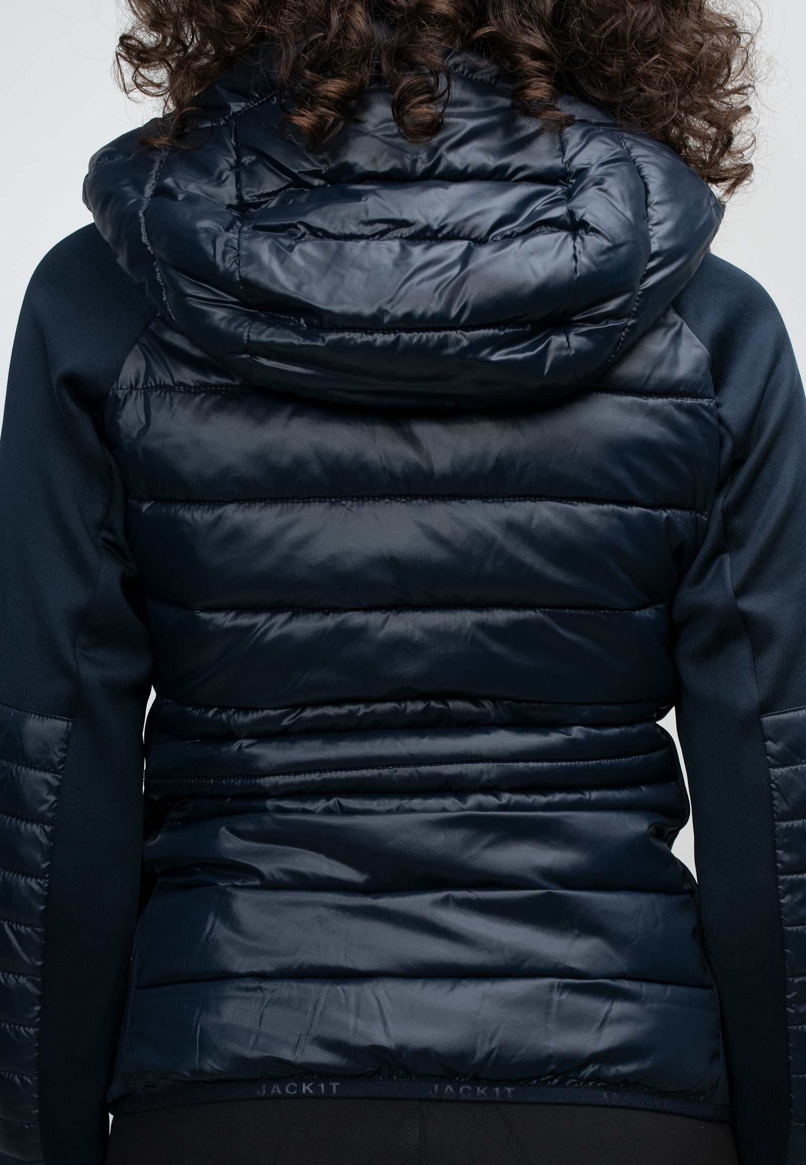 Back view of women's navy hooded jacket showcasing lightweight water-resistant fabric and hood details.