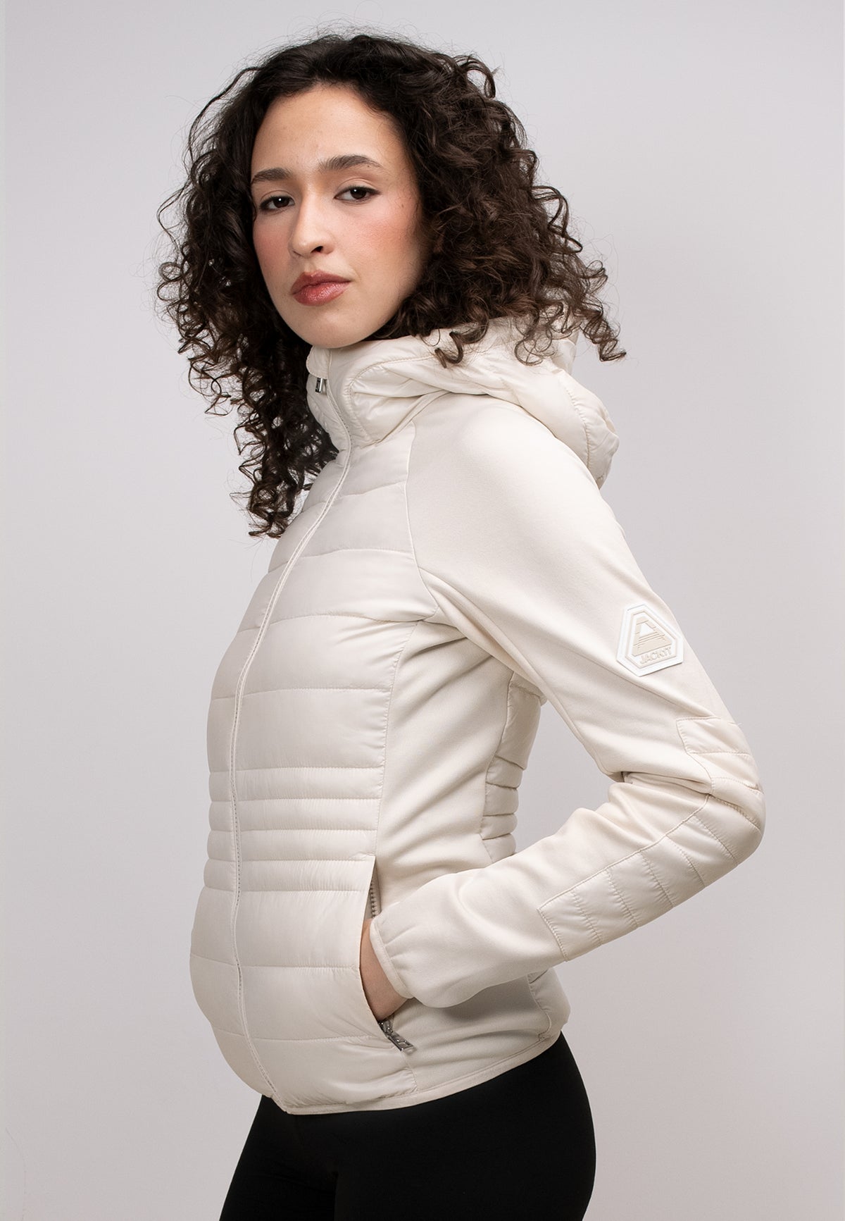 Model wearing a women's cream hooded jacket with a zippered hood and stylish design.