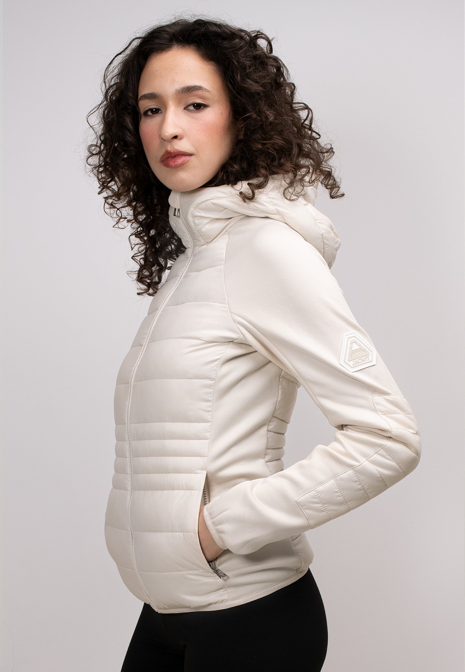 Model wearing a women's cream hooded jacket with a zippered hood and stylish design.