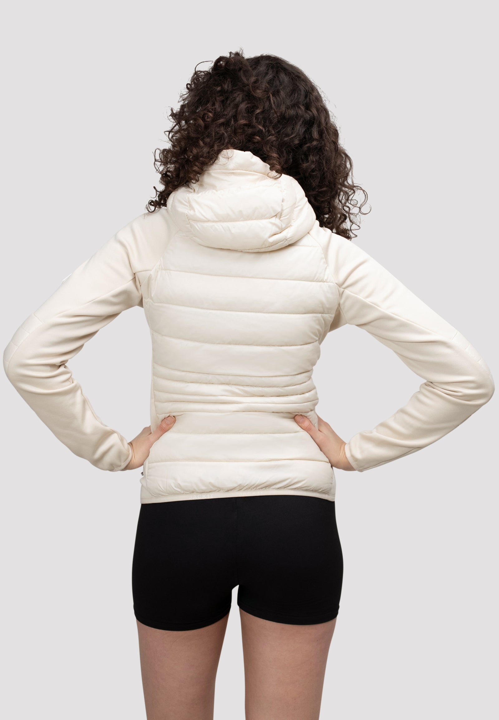 Back view of women's cream hooded jacket on model, showcasing lightweight design and fit.
