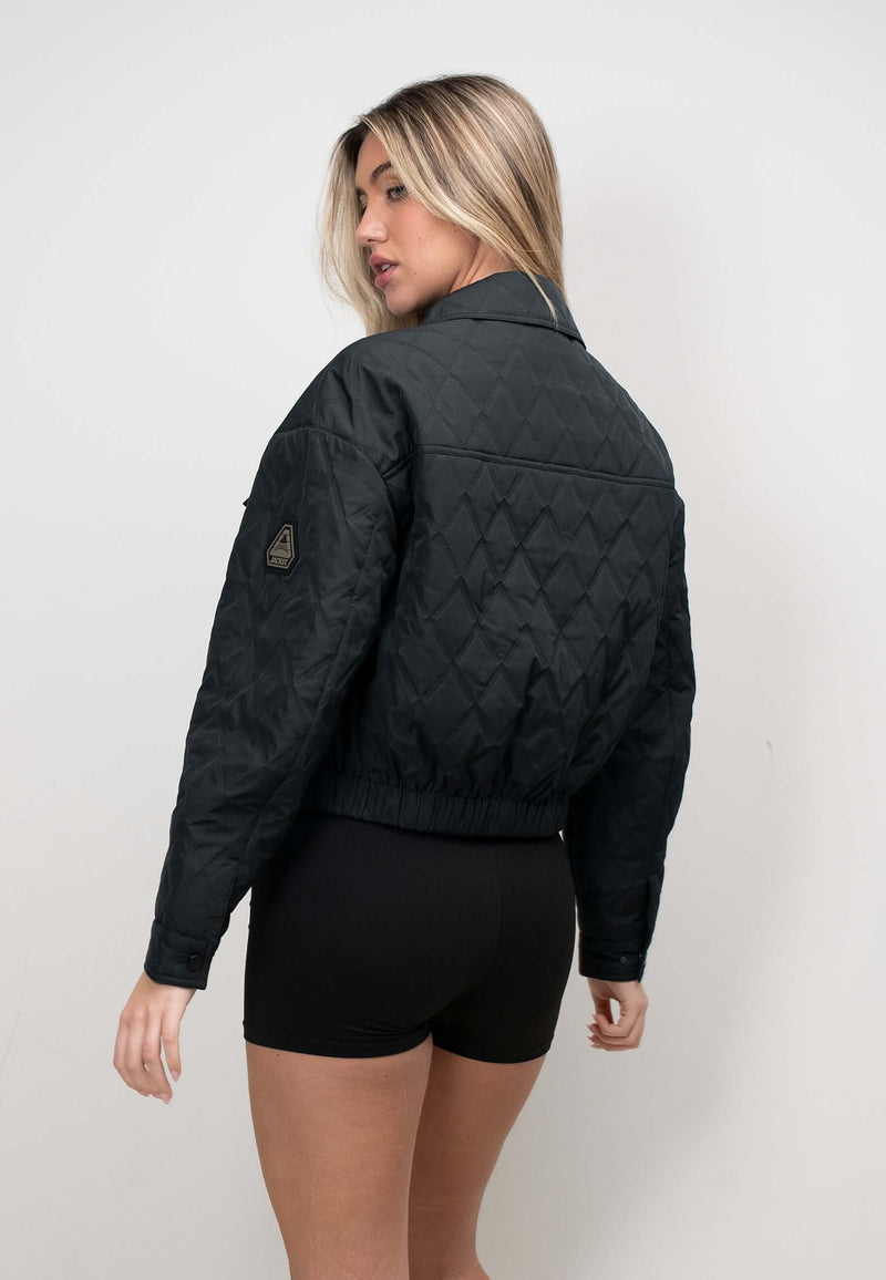 Model wearing a women's black quilted shirt jacket, showcasing its lightweight and casual style.