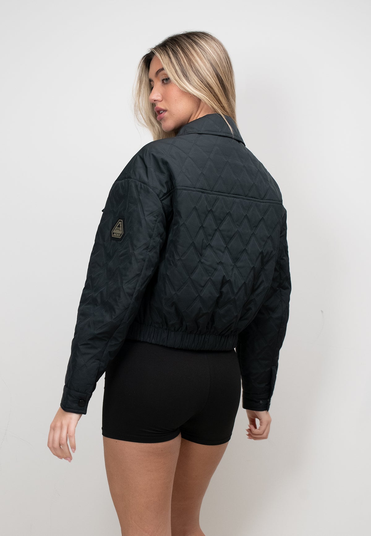 Model wearing a women's black quilted shirt jacket, showcasing its lightweight and casual style.