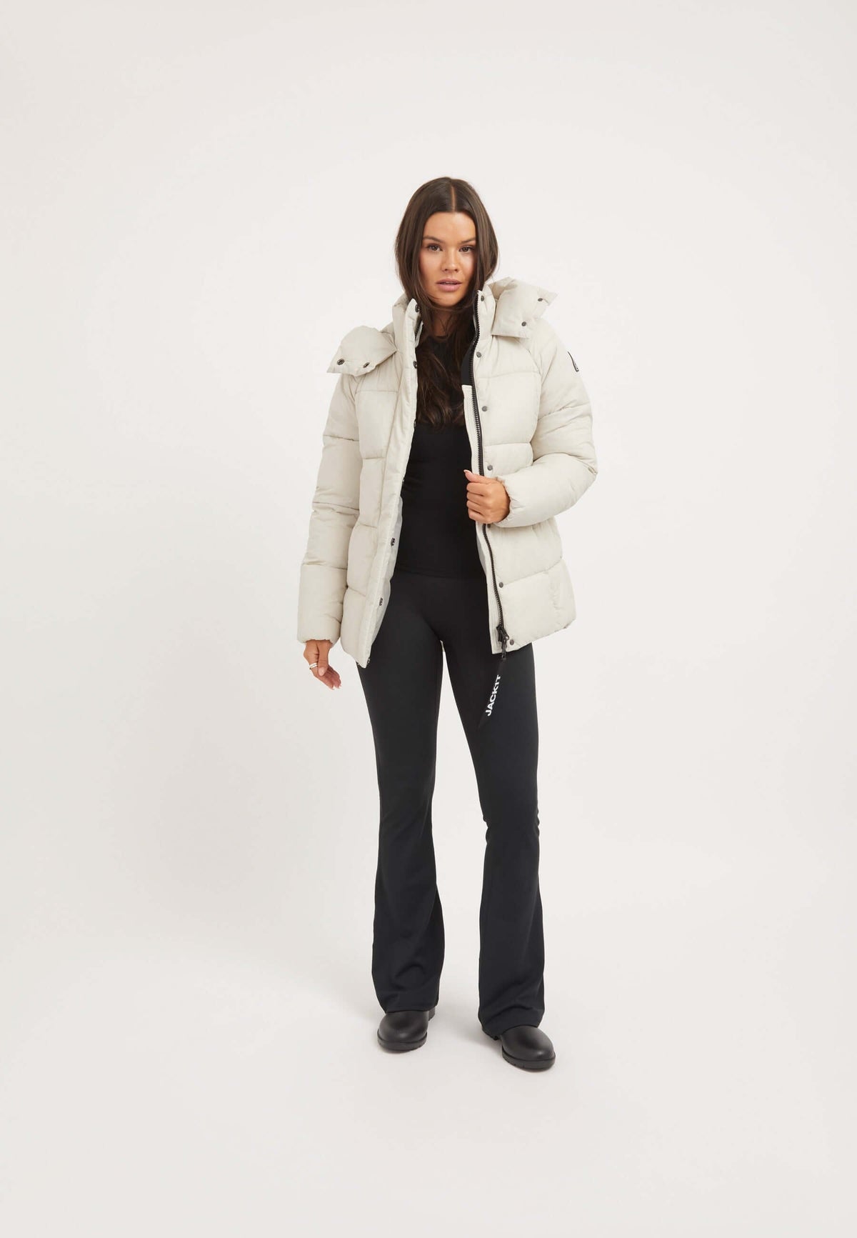 Model wearing Cloud Prime Jacket in Stone, a lightweight puffer jacket stone with adjustable hood and premium insulation.