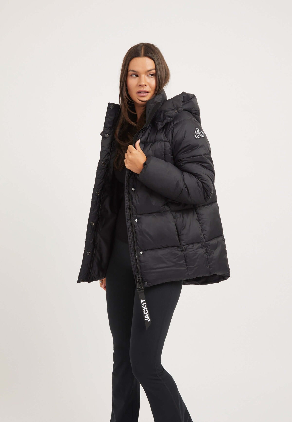 Model wearing the womens black puffer jacket featuring adjustable hood and two way zips, ideal for versatile weather.