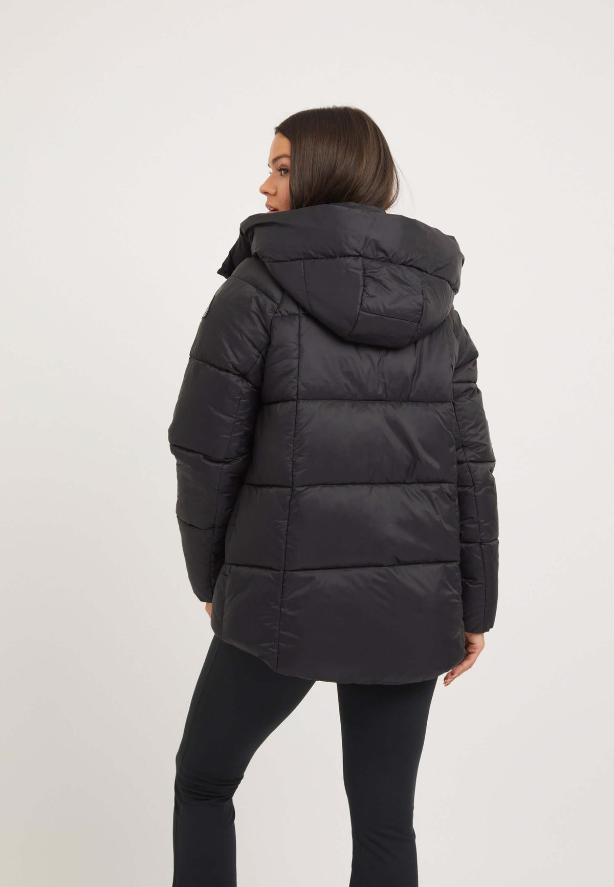 Womens black puffer jacket featuring tapered design, adjustable hood, and lightweight construction, perfect for adaptable weather.