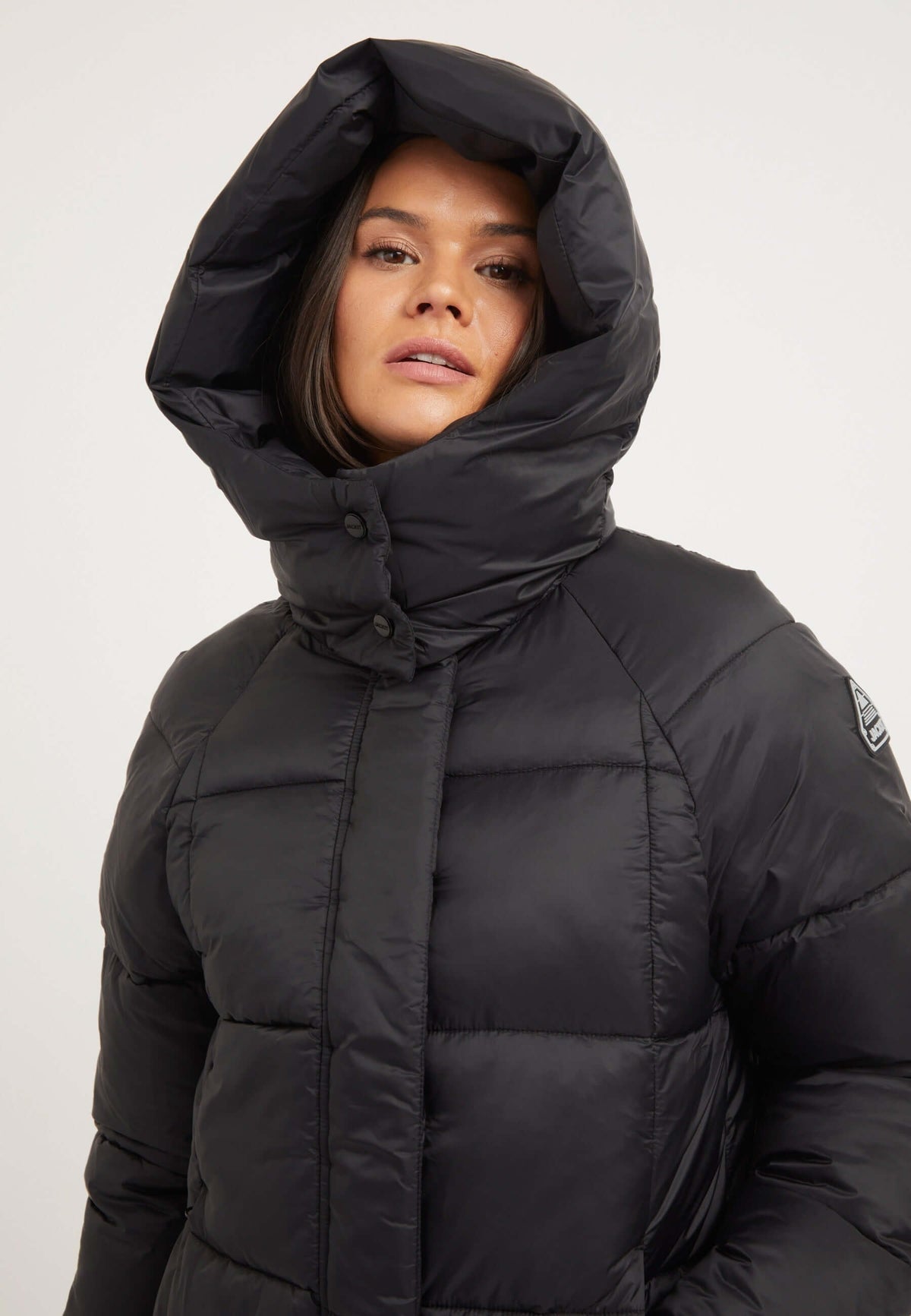 Close-up of a woman wearing a womens black puffer jacket with an adjustable hood and premium insulation.