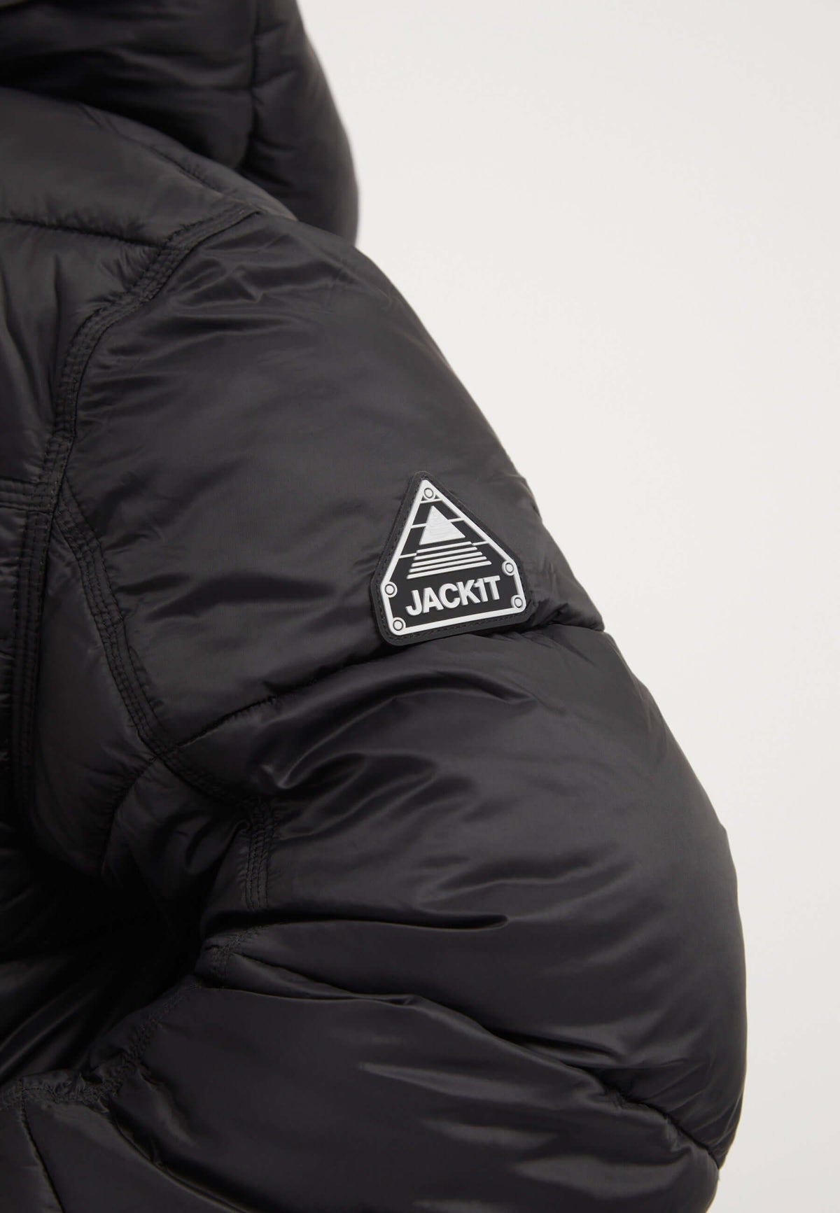 Close-up of the Cloud Boss Jacket Black showing the reflective badge detail on the arm. Perfect for womens black puffer jacket.