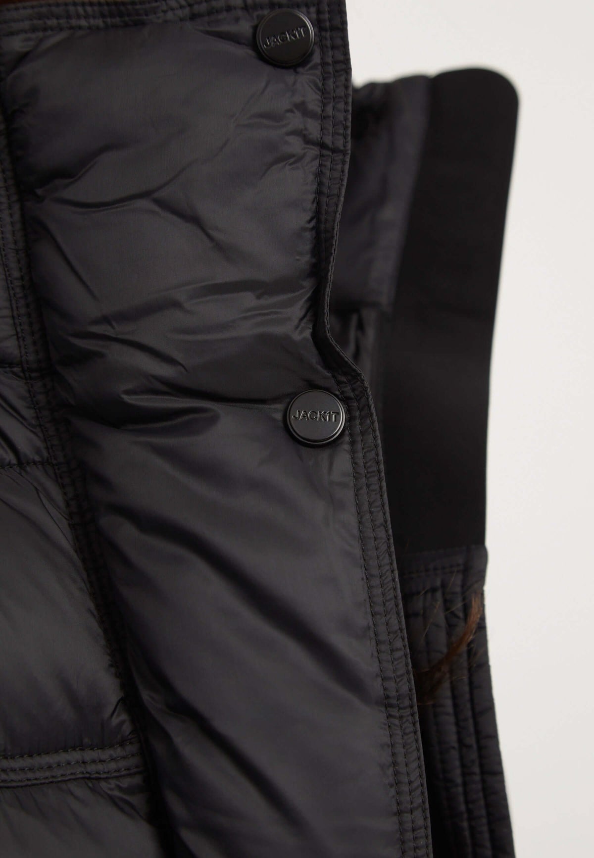 Close-up of the Cloud Boss Jacket Black showing the interior insulation and buttons in a lightweight design for womens black puffer jacket.