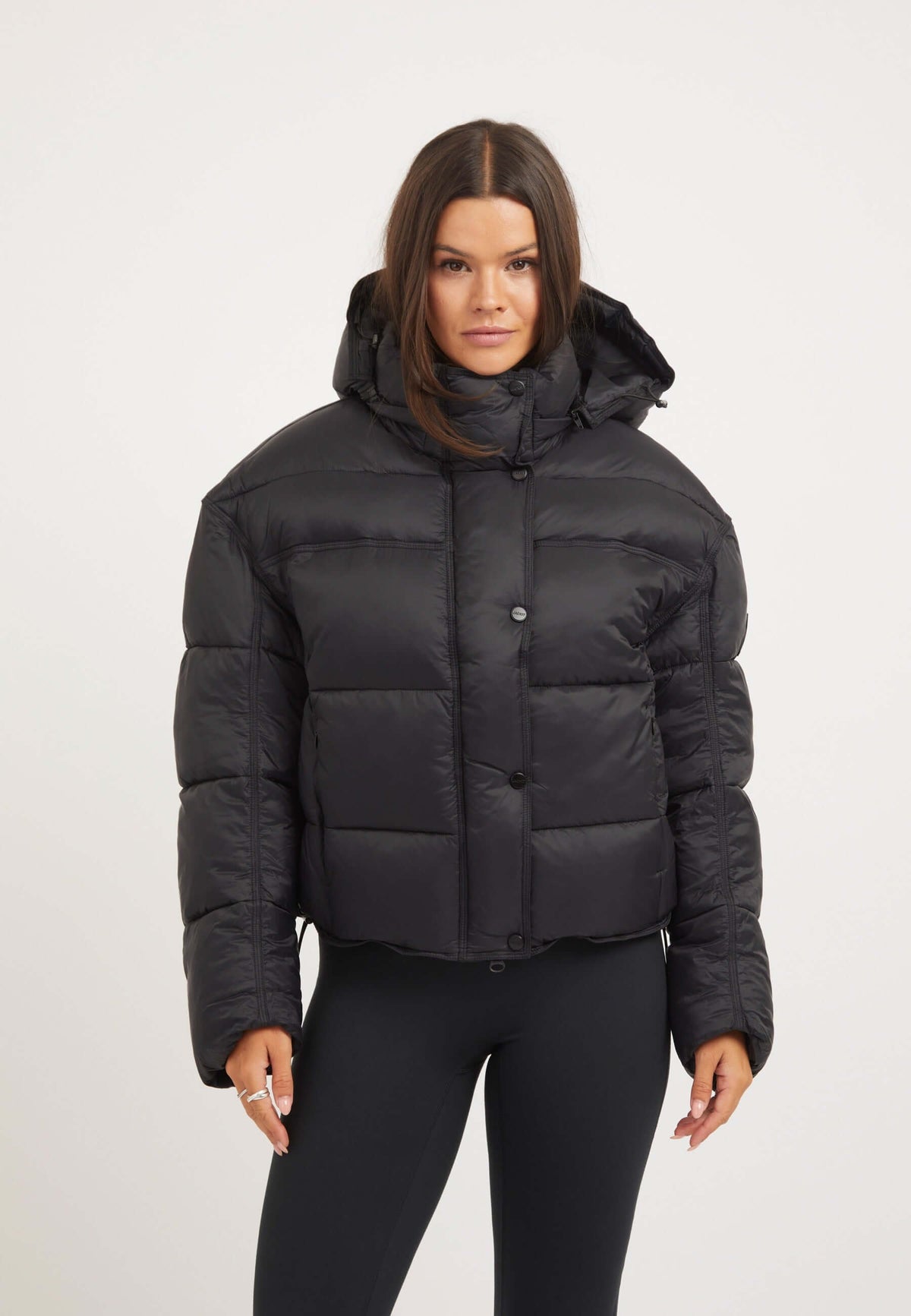 Womens black puffer jacket featuring oversized drop shoulder silhouette and removable hood.