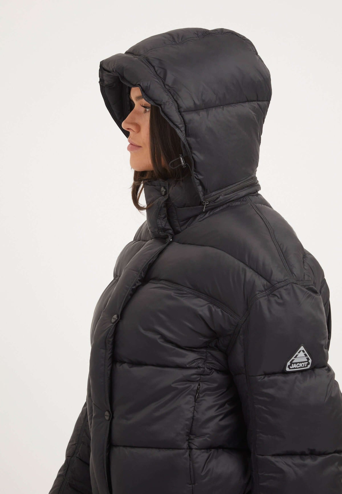 Side view of a woman wearing a womens black puffer jacket with a hood, showcasing the oversized silhouette and premium insulation.