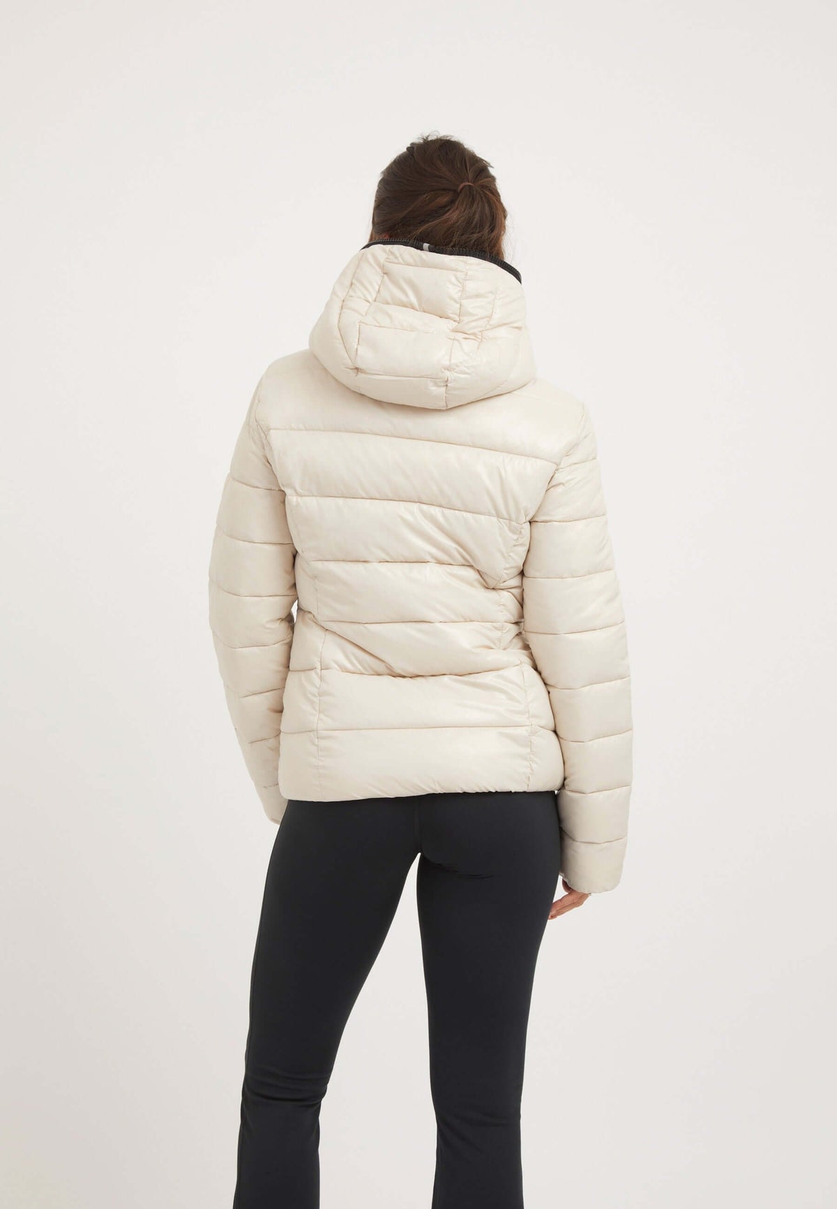 Back view of a woman wearing the R3D Slick Racer Jacket Stone, a stylish womens racer puffer with premium insulation.