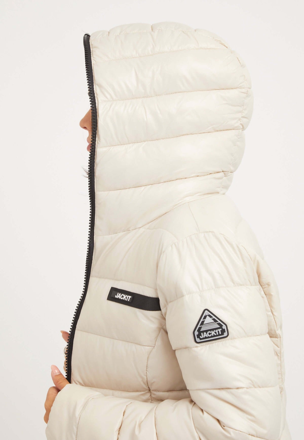 womens racer puffer in stone color with hood and zip, showcasing tapered fit and premium insulation.