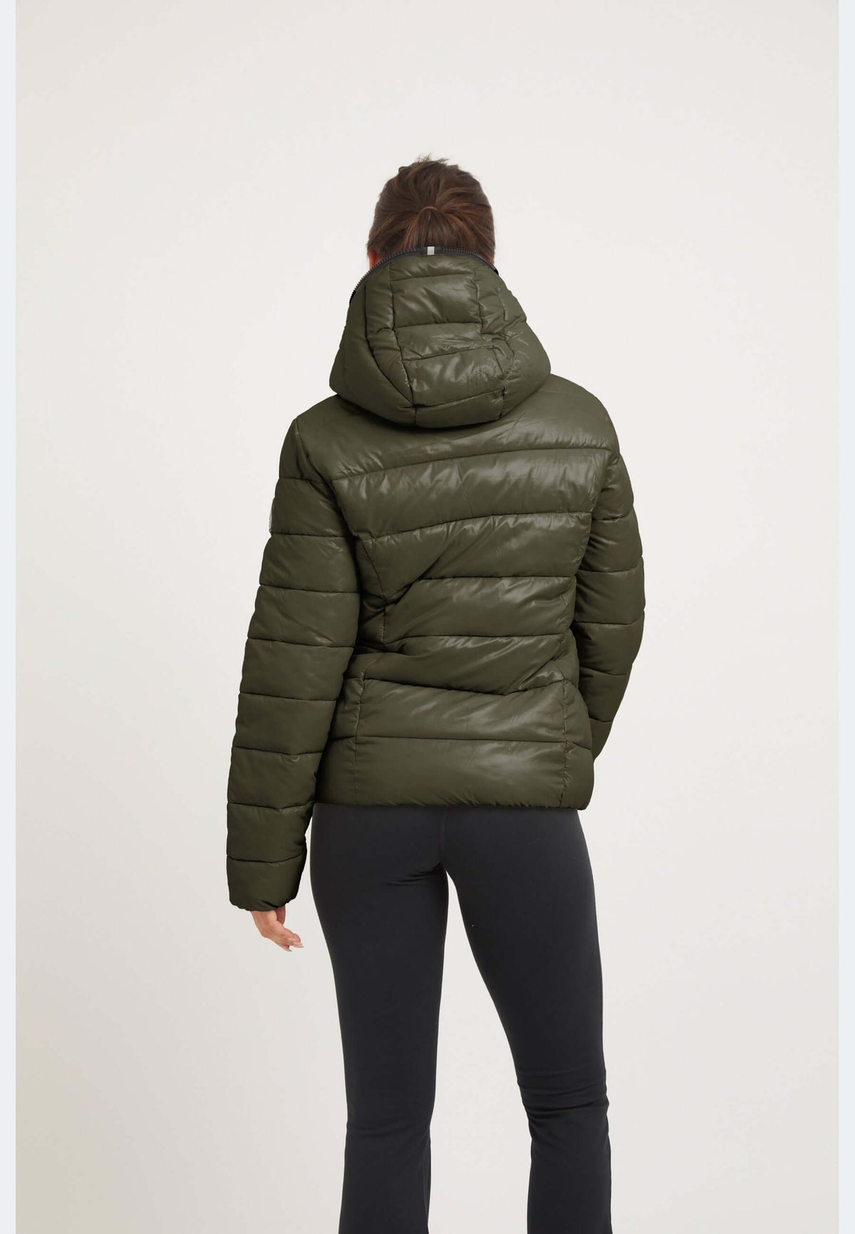 Back view of a woman wearing the R3D Slick Racer Jacket in Olive, showcasing a fitted puffer jacket style.
