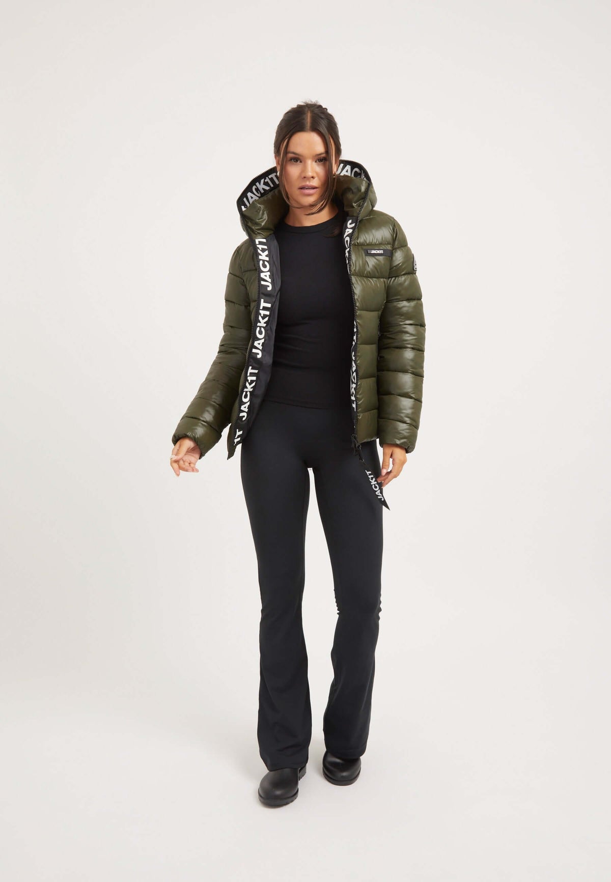 Model wearing R3D Slick Racer Jacket Olive, a fitted puffer jacket, combined with black pants and stylish footwear.