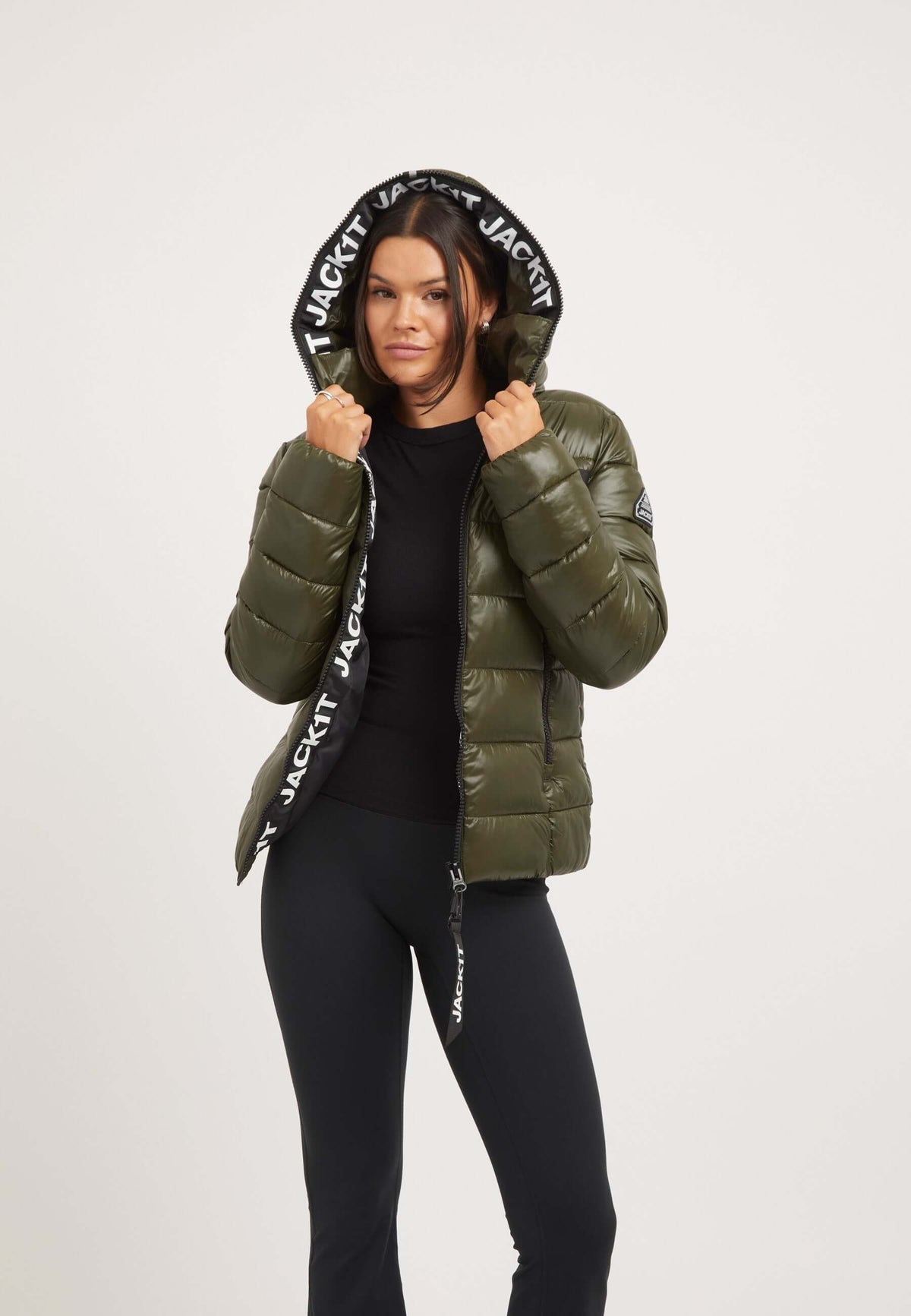 Model wearing R3D Slick Racer Jacket Olive, fitted puffer jacket with a hood and elastic details, styled for a fashionable look.