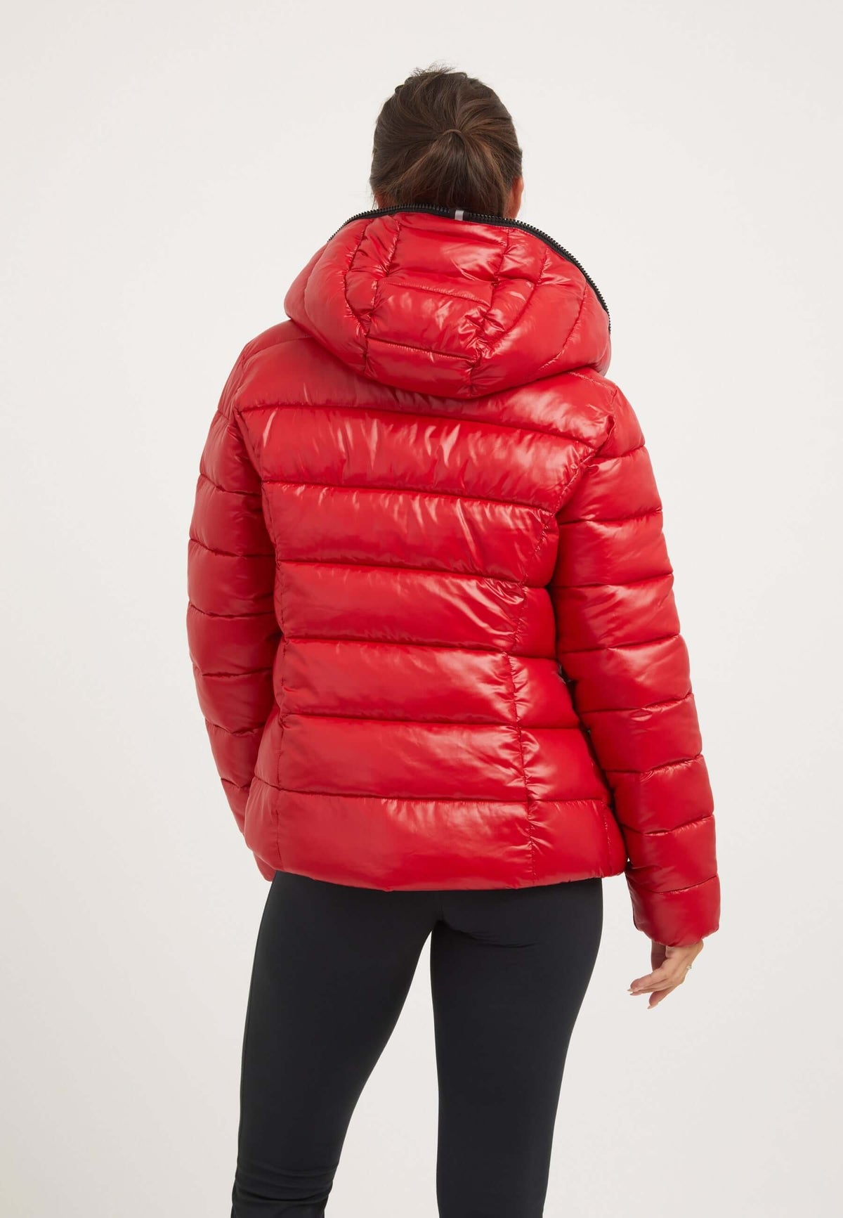 Back view of a woman wearing a short red jacket with a hood in cherry red color.