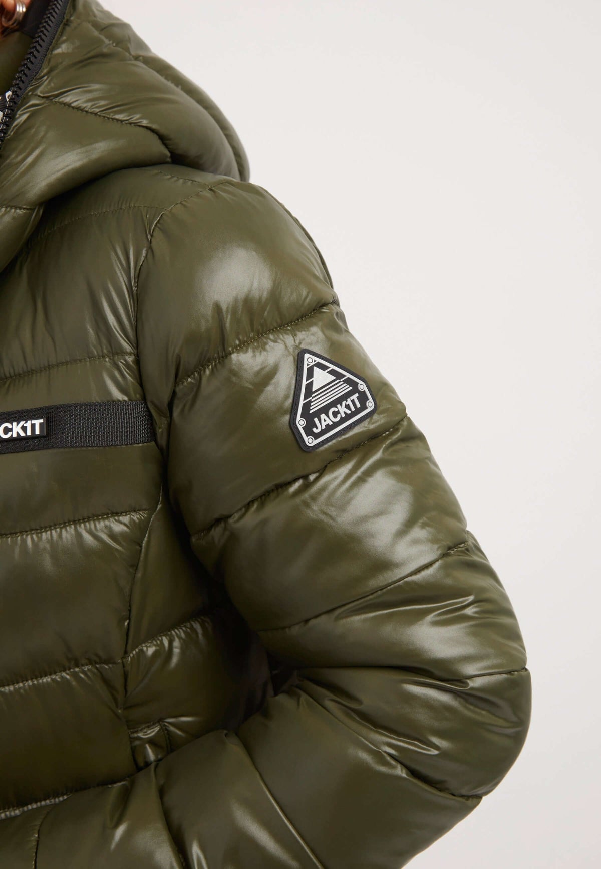 Close-up of R3D Slick Coat Olive, a mid length olive coat with a glossy finish and a logo patch on the sleeve.