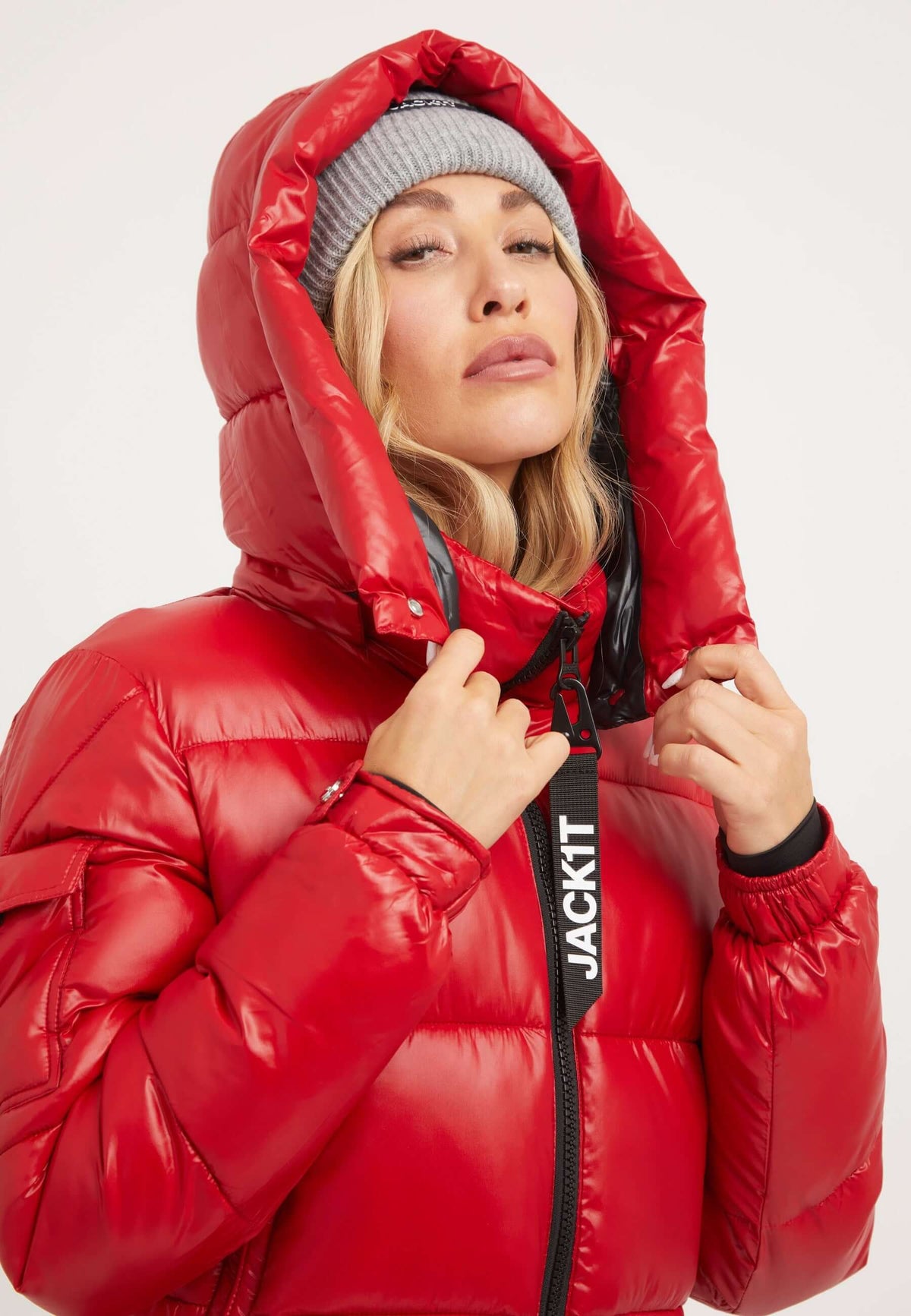 Model wearing a red puffer jacket with hood, showcasing a tapered racer fit and stylish design.