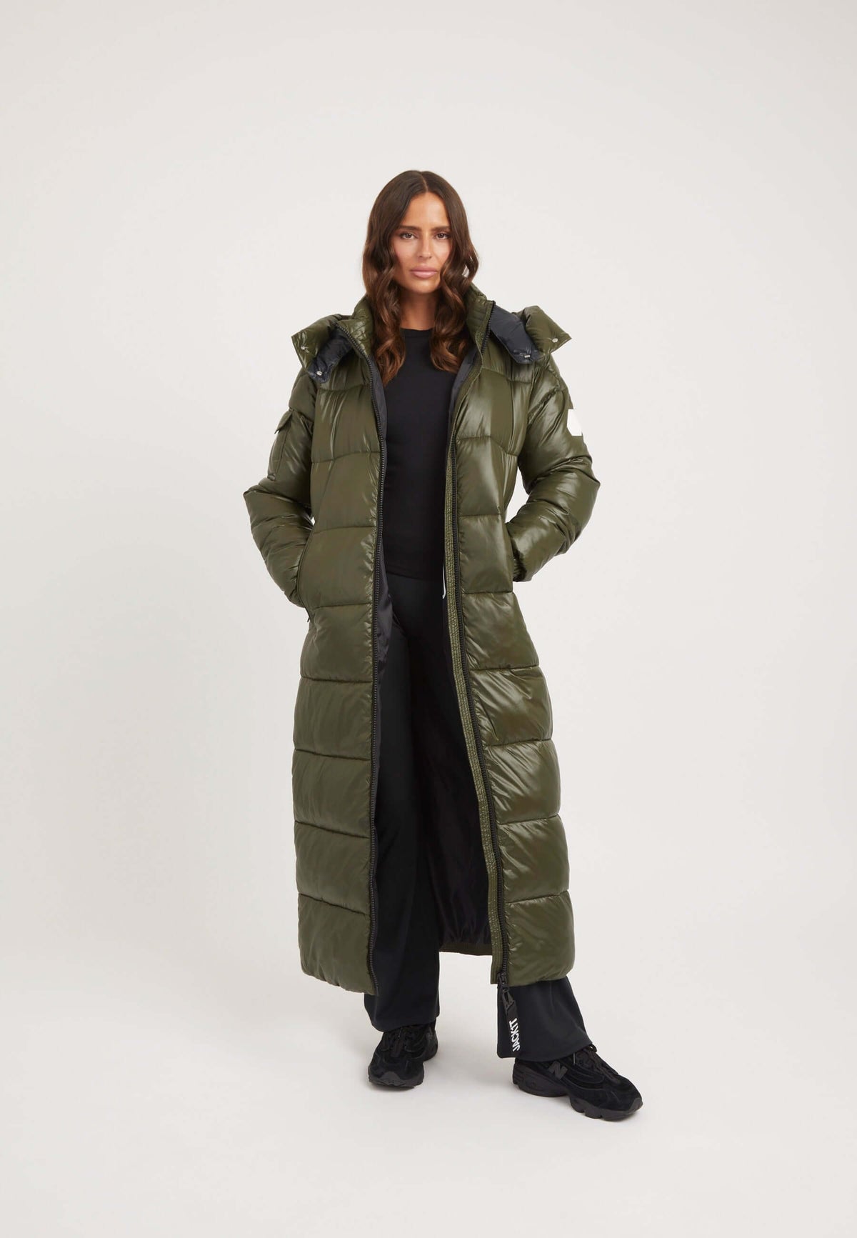 Model wearing EZ Slick Ultra Long Coat in olive, showcasing full length silhouette, perfect for chilly weather, Extra long puffer coat.