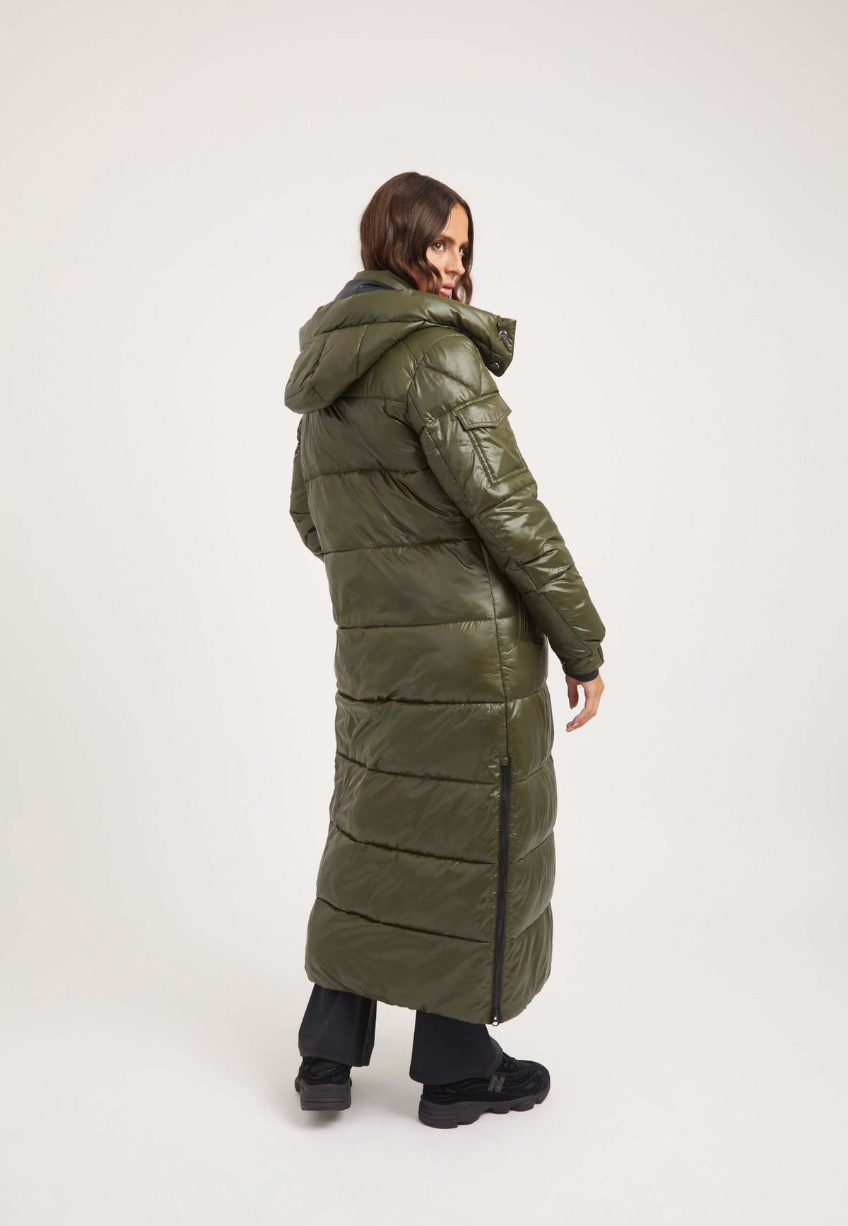 Woman wearing EZ Slick Ultra Long Coat Olive, a stylish extra long puffer coat with removable hood and side vents.