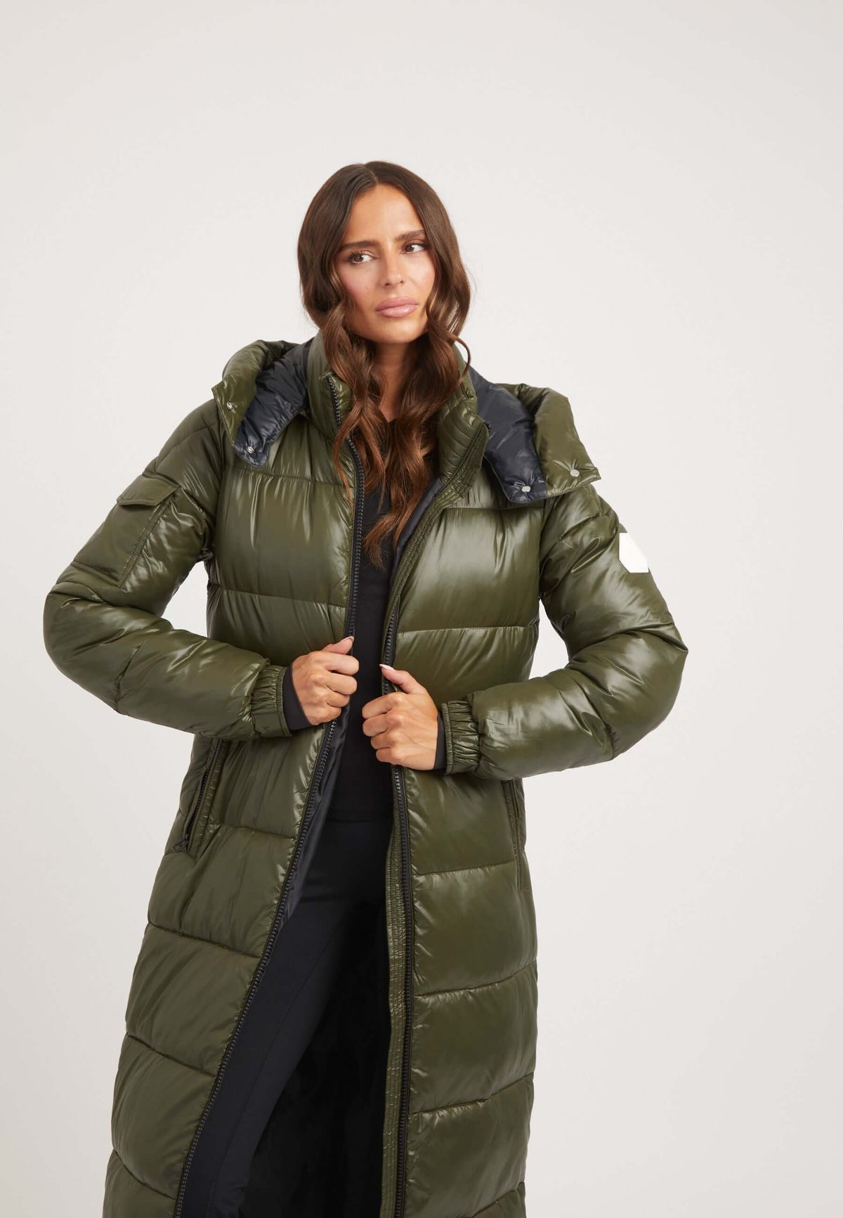 Woman modeling EZ Slick Ultra Long Coat in Olive, a stylish Extra long puffer coat featuring premium insulation and removable hood.