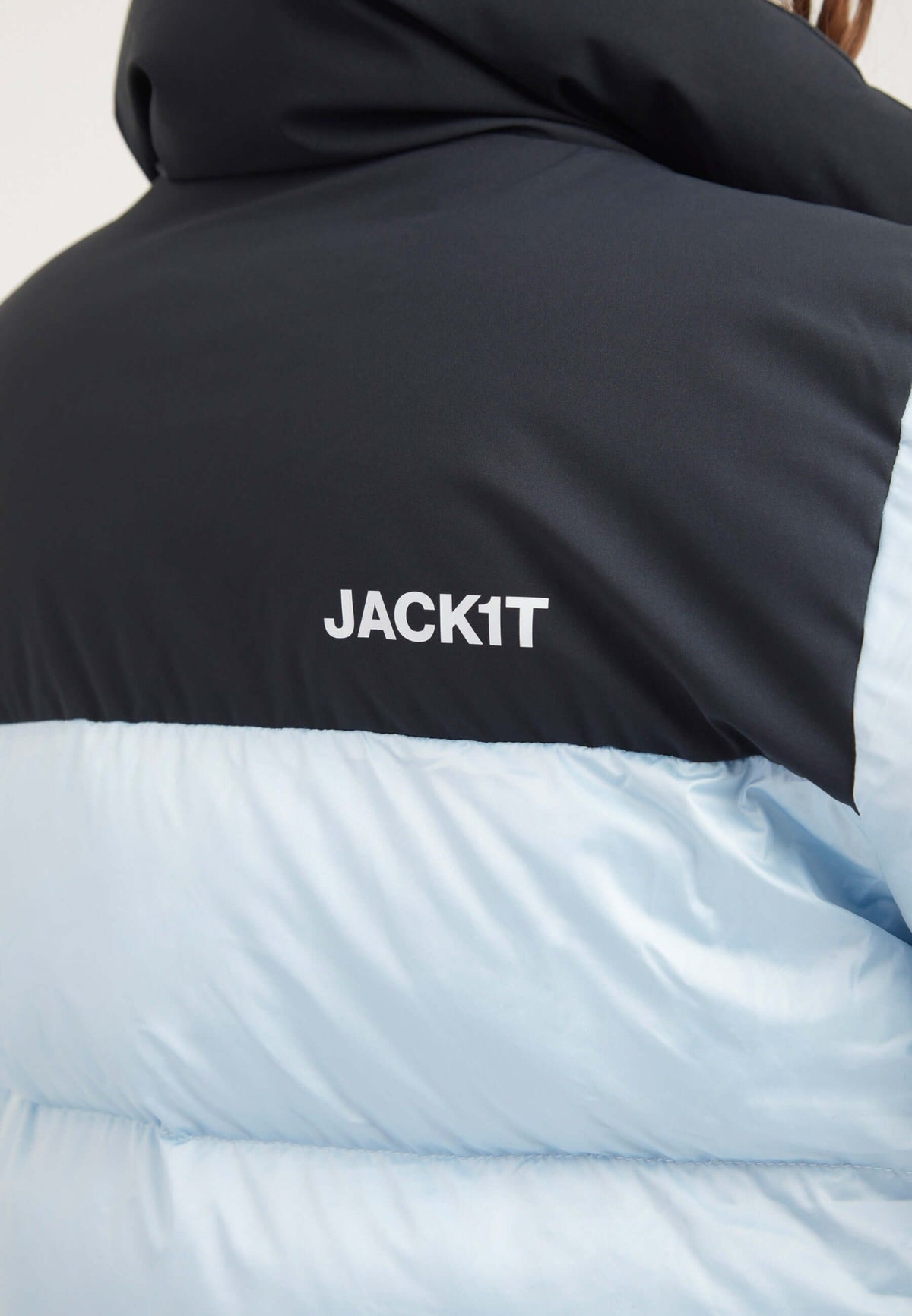 Back view of a person wearing a Diamond Funnel Jacket in powder blue and black, showcasing the funnel neck jacket design and JACK1T logo.