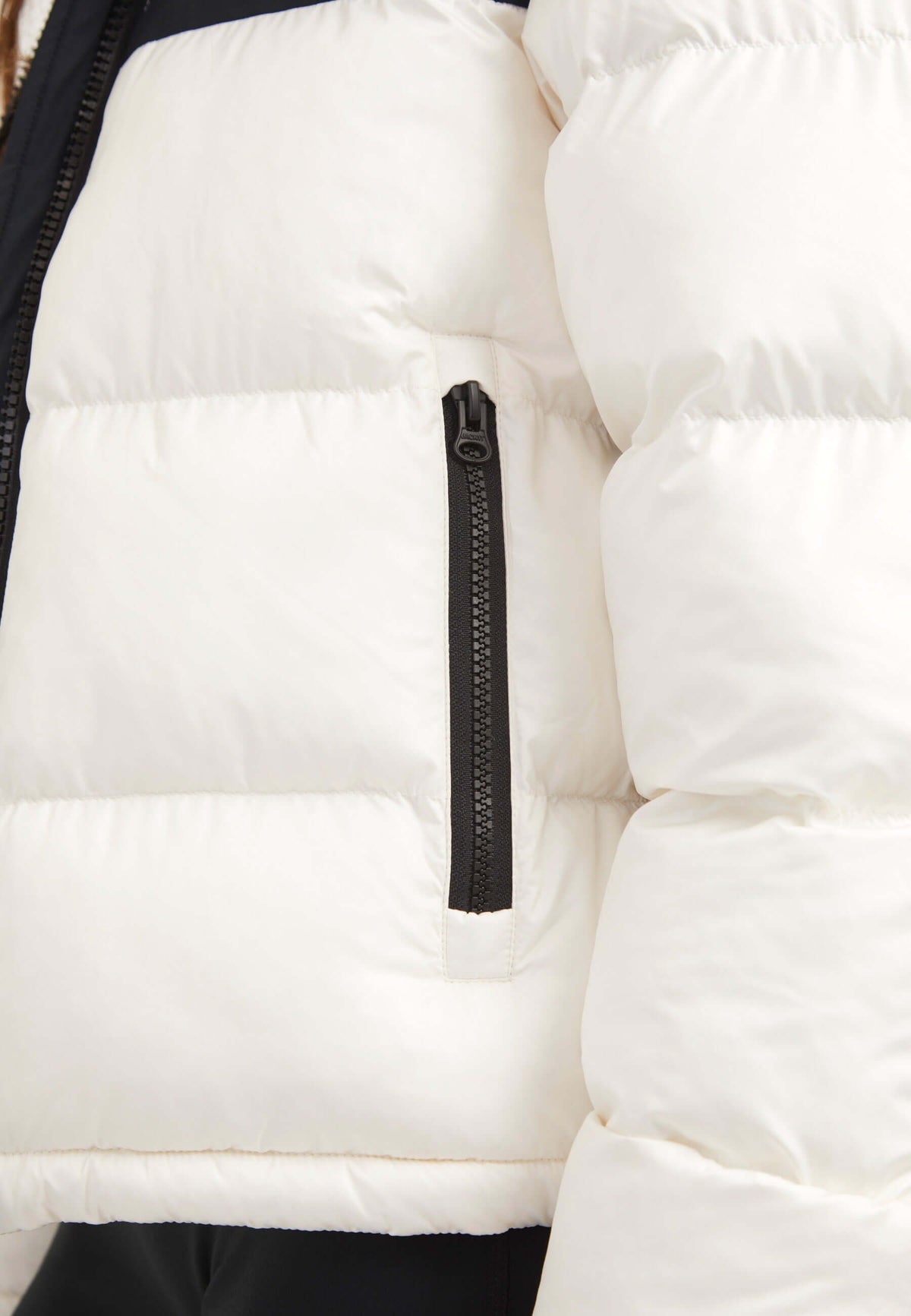 Close-up of the zip pocket on a Diamond Funnel Jacket Snow Black, featuring a funnel neck jacket design.