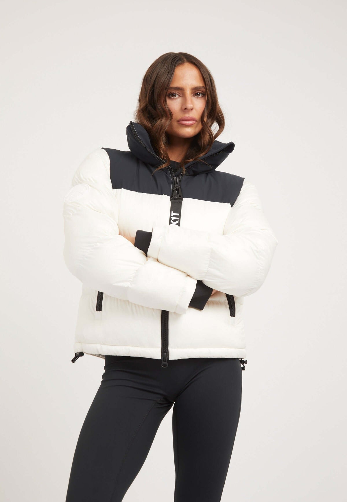 Woman wearing Diamond Funnel Jacket in Snow Black, featuring funnel neck jacket and contrasting color panels.
