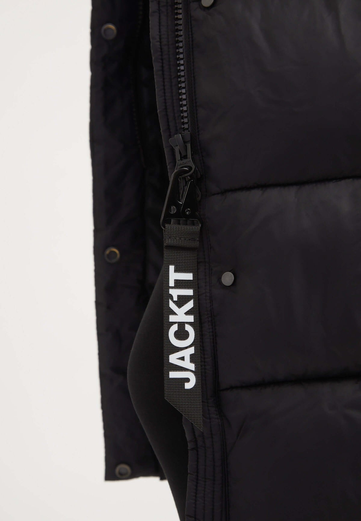 Close-up of the zipper and tag on a womens long puffer coat in black, showcasing premium materials and detail.